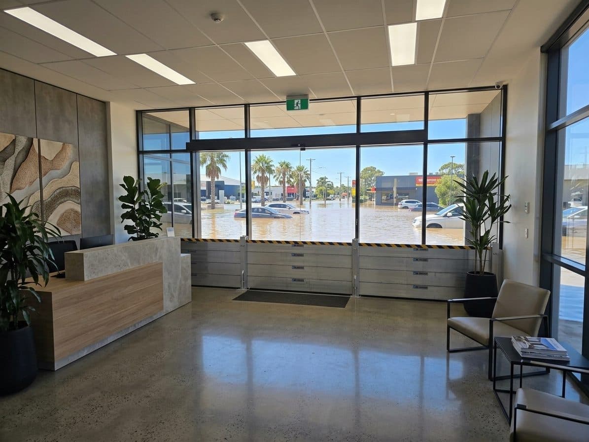 Aluminum flood barrier fitted across an office lobby entrance